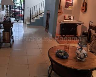 Interior living area with ceramic tile floors, staircase, and eclectic decor in house for sale La Chorrera