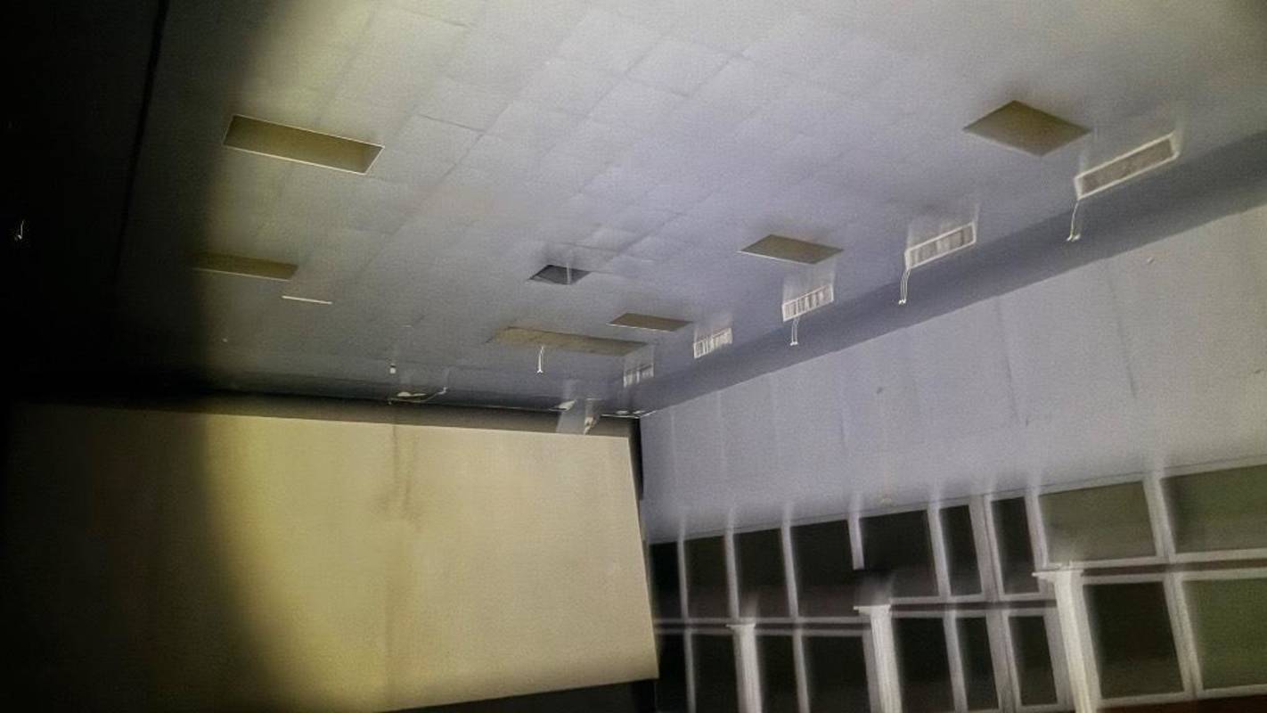 Dimly lit auditorium or movie theater with recessed ceiling lights and large projection screen in Panama City
