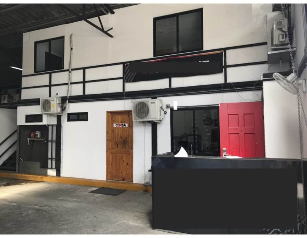 Front exterior industrial unit with red garage doors and parking area on Avenida Santa Elena Panama City
