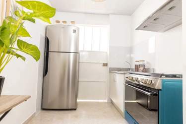 Bright coastal-themed bedroom with floral linens woven wall decor in PH Torres de Toscana Panama
