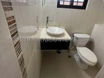 L-shaped modern kitchen with dark cabinetry double sink window view house La Chorrera Panama