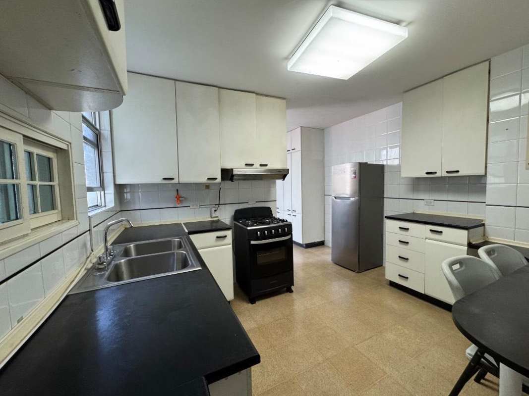 Modern white kitchen with black counters, appliances in PH Crystal El Cangrejo condo