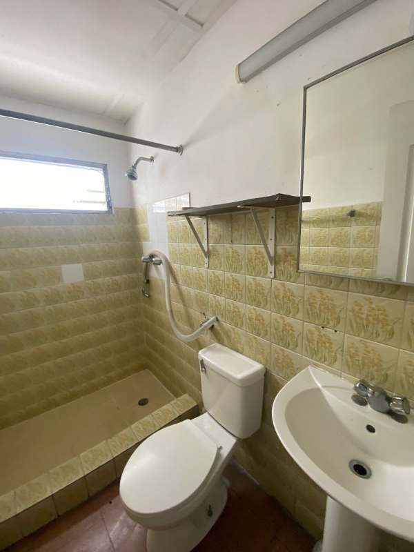 Vintage bathroom with walk-in shower pedestal sink and yellow tile PH Analisa Carrasquilla Panama