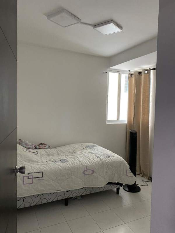 Bright minimalist bedroom with large window and AC in Edison Park apartment Panama City