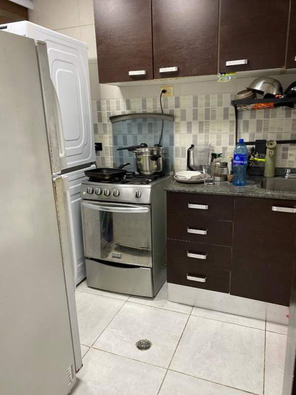 Compact contemporary kitchen with granite counters, dark cabinets, stainless appliances in Edison Park apartment Panama City