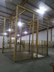 Fenced interior warehouse area with storage boxes and wooden beams in Panama