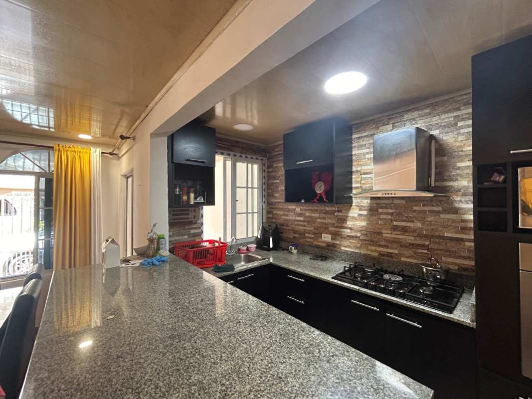 Bathroom with green tiles, gold mirror frame, shower curtain inside Don Bosco Panama house