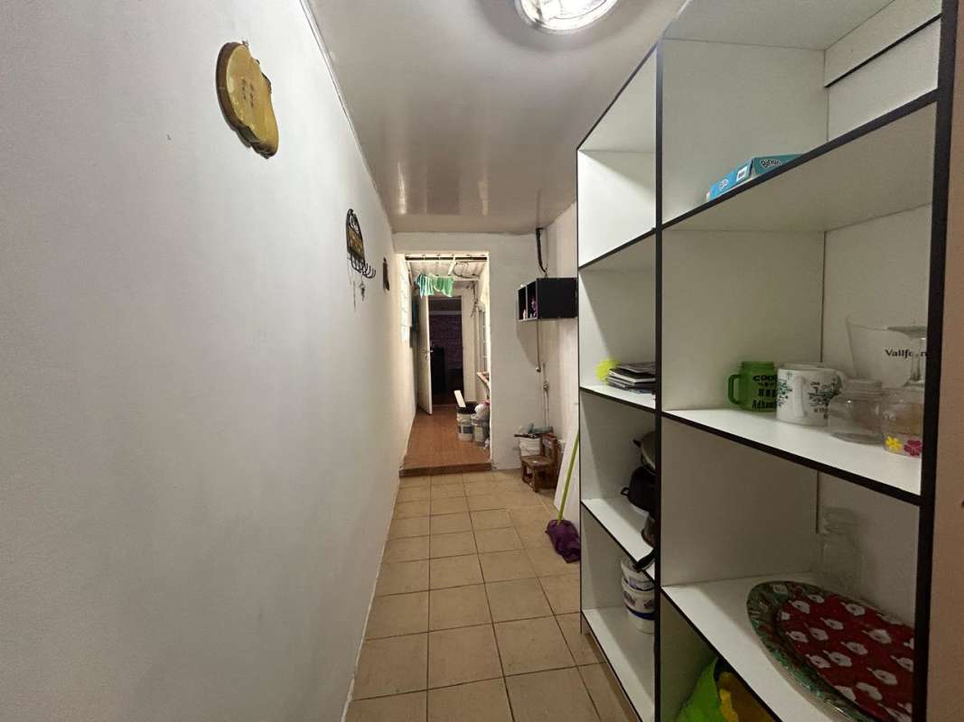 Bathroom with mosaic tiles, gold sunburst mirror, glass enclosed shower in Panama Don Bosco house