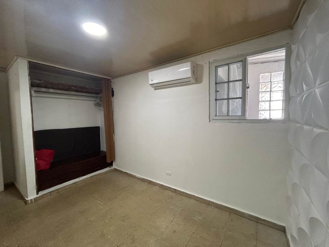 Bedroom with AC, textured accent wall, and tile floor at house Urbanización Los Robles Don Bosco Panama