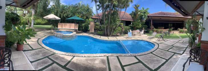 Outdoor terrace with dining and lounge area by pool of luxury beach house in Chumico Panama