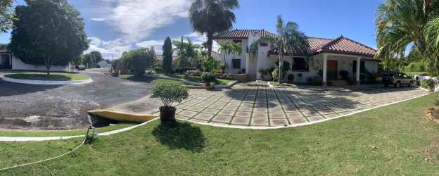 Front view of Mediterranean luxury villa with palm trees and driveway in Chumico Beach Panama
