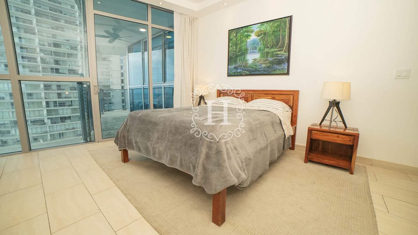 Master bedroom featuring ocean view and floor-to-ceiling windows in Grand Tower Punta Pacifica luxury apartment