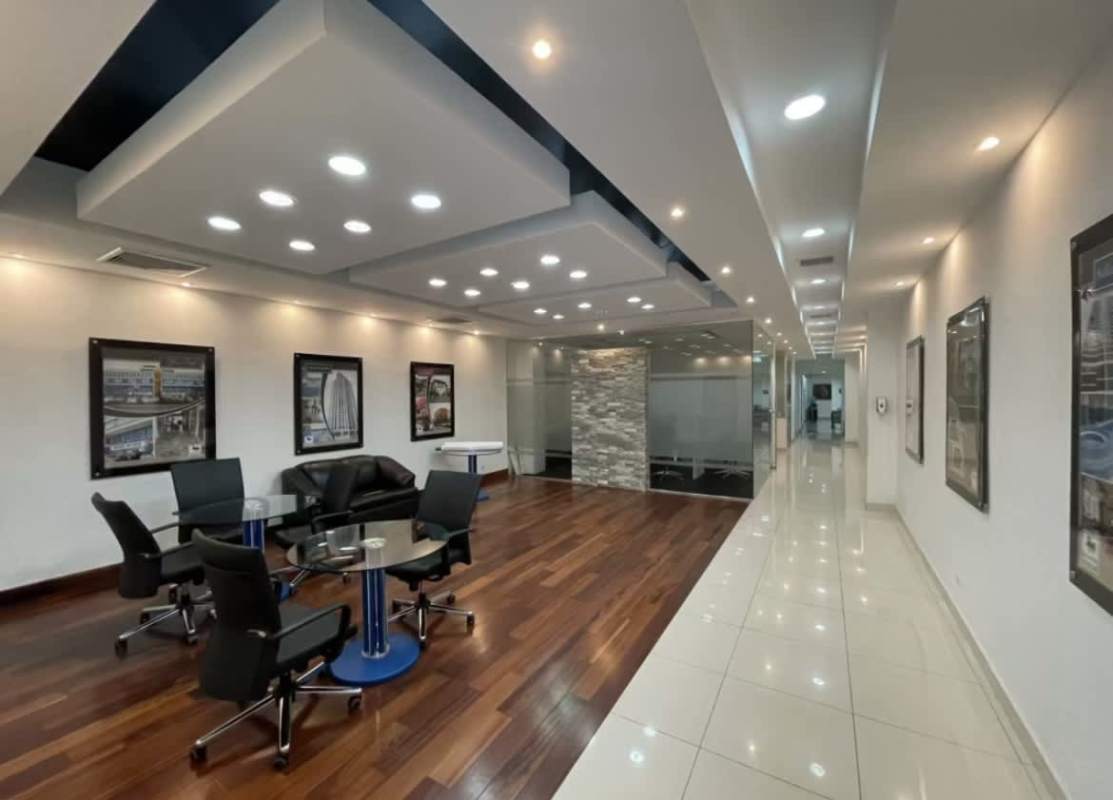 Luxurious business lounge area with wood floors, accent wall, and comfortable furniture in Obarrio Panama