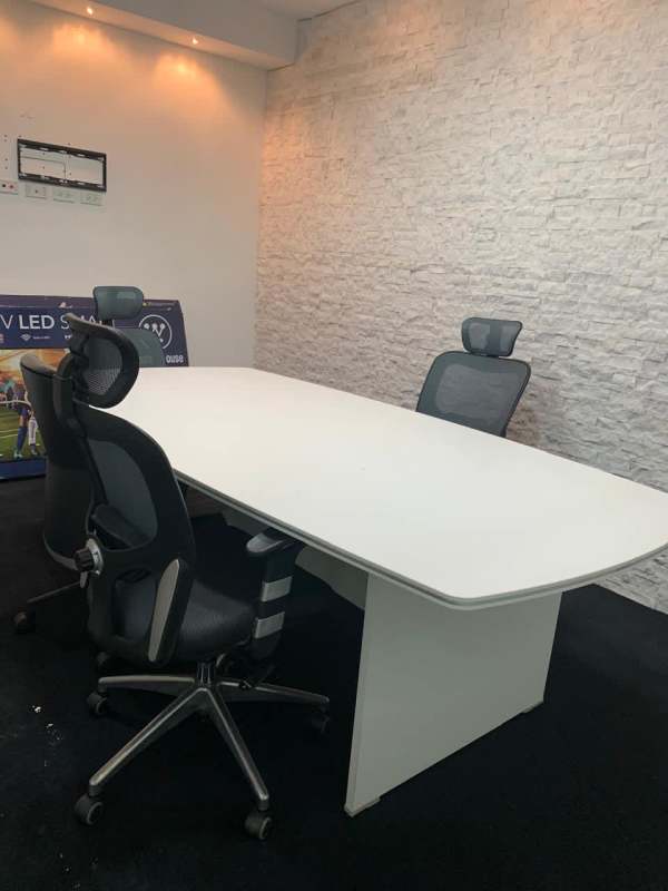 Minimalist white brick wall conference room with black chairs and white table Via España Panama