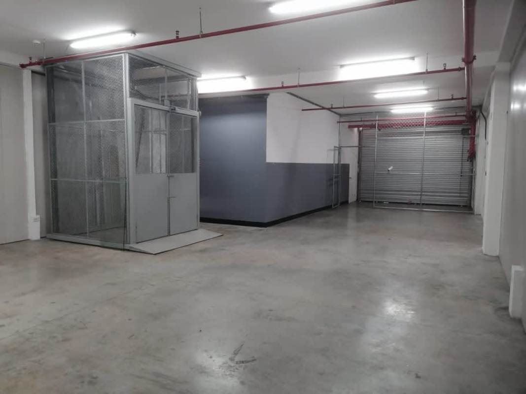 Small kitchenette with cabinets, water dispenser and wood flooring mezzanine office Panama warehouse
