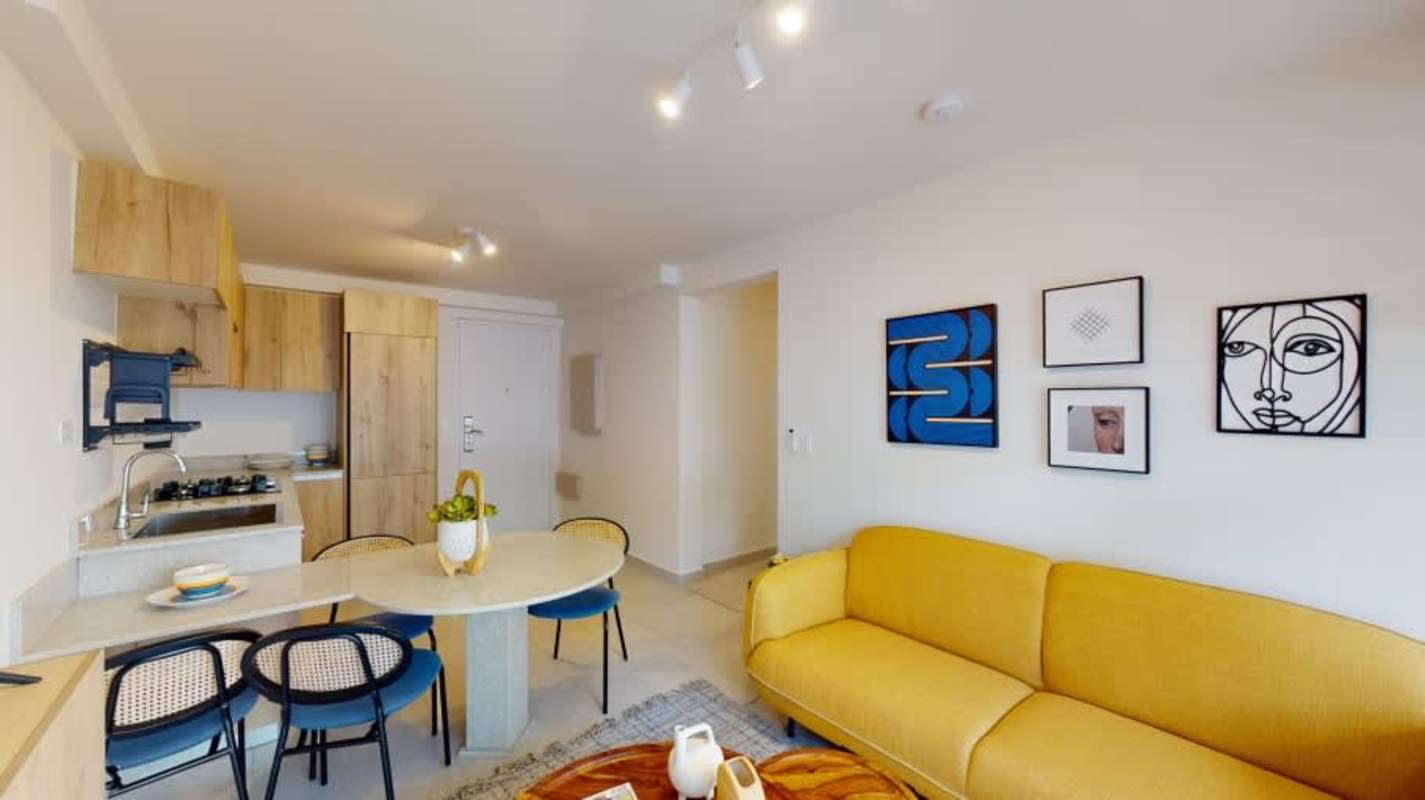Stylish kitchen with integrated dining space, modern cabinetry, yellow sofa PH Armonía Panama City