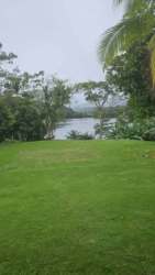 Tropical garden with green lawn and lakefront view at finca in San Juan Capira Panama