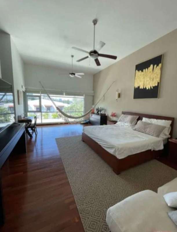 Master bedroom with natural light, built-in closet, ceiling fan, wood floors in Panama City home