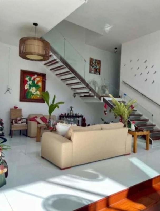 Modern living room beige sofa indoor plants wall art floating glass staircase Panama City home