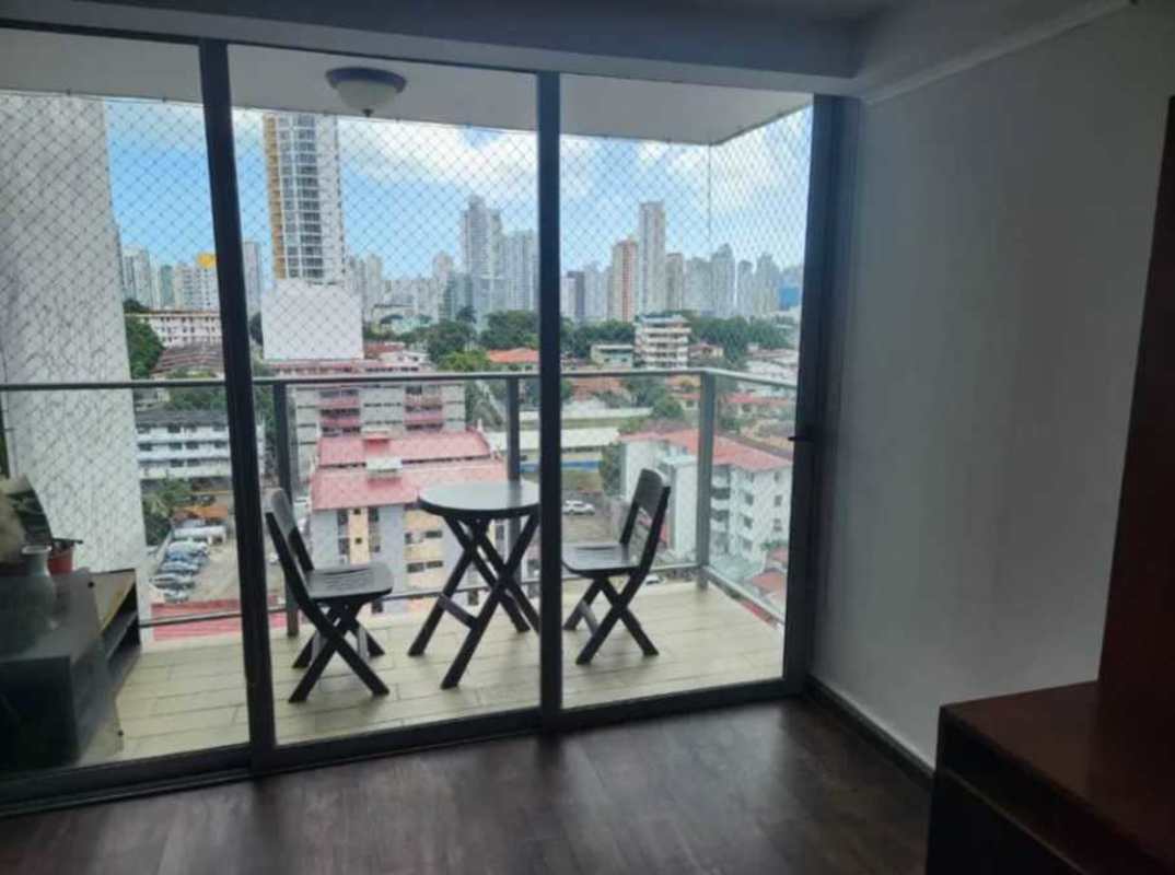 Living room with glass balcony doors, safety netting and city view at PH San Francisco Bay Panama City