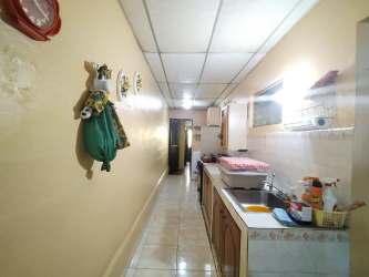 Traditional galley kitchen with wood cabinets and tile floor Panama City