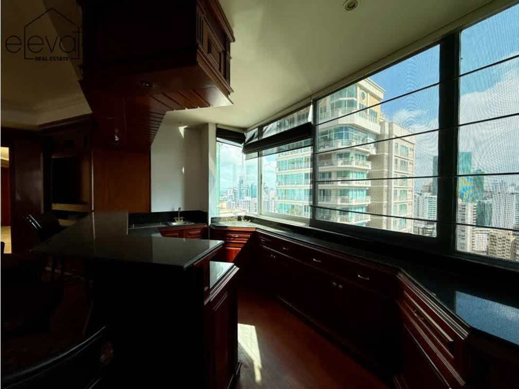 Contemporary kitchen with black granite countertops and city view windows in penthouse PH Tuscany Punta Paitilla Panama