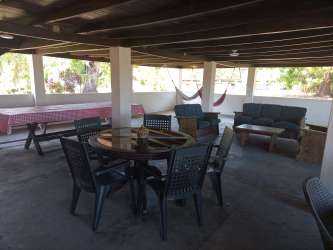 Rustic country kitchen with floral curtains and exposed wood beams at recreation finca in Chame Panama