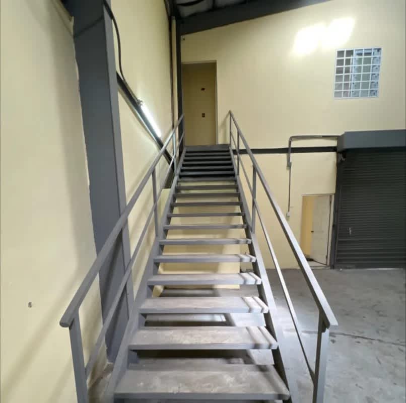 Warehouse space with metal stairs and a large rolling shutter gate in Chanis Panama commercial galera