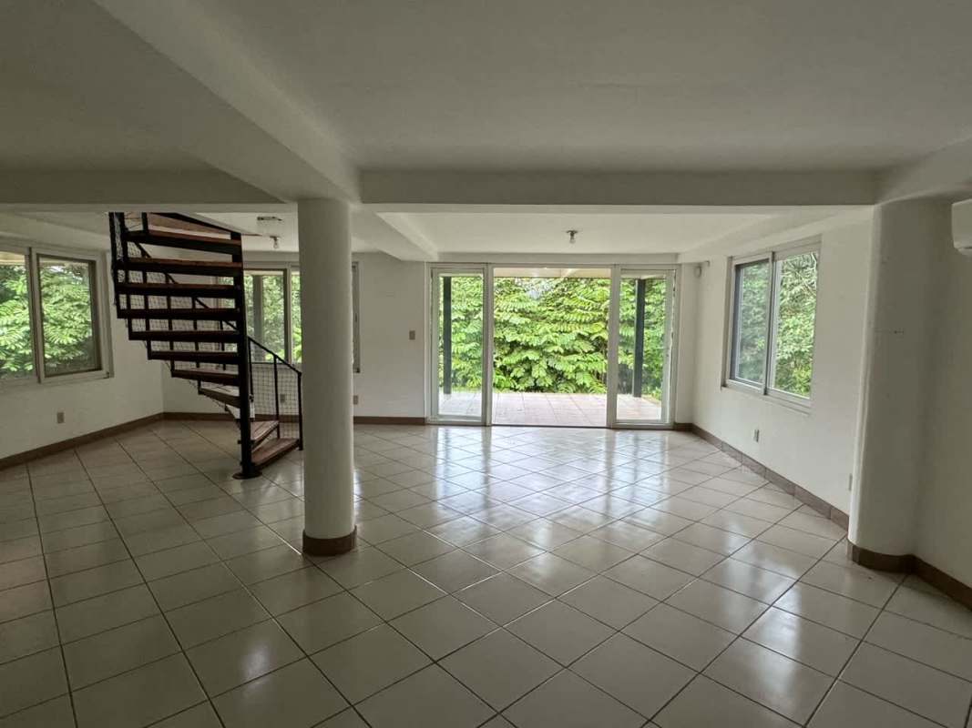 Spacious living area with large windows and spiral staircase rental house Cerro Ancón