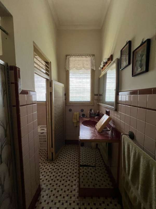 Vintage style bathroom with classic tiled walls and mosaic floor, natural light, in house at Las Cumbres Panama