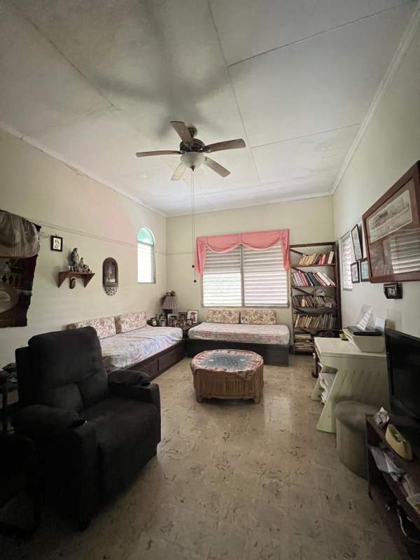 Spacious traditional living room with ceiling fan, piano and large windows in Las Cumbres Panama