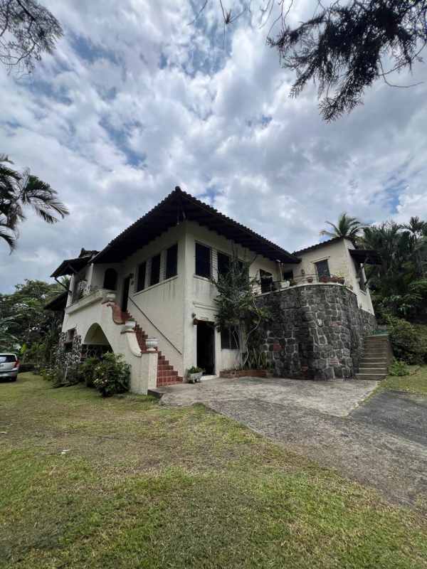 Covered balcony terrace with terracotta tiles, landscape views at house in Las Cumbres Panama