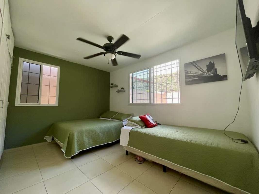 Kitchen with stainless refrigerator, stove, light wood cabinets and decorative tile in Villa Lucre Panama house for sale