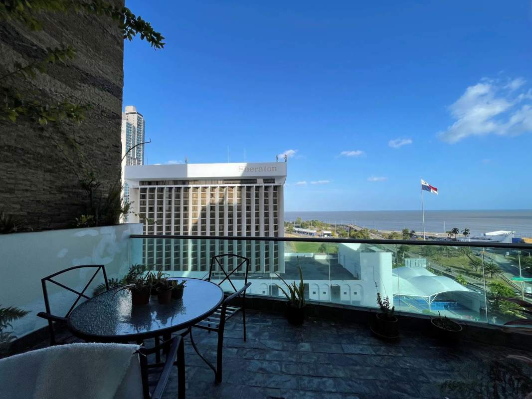 Spacious kitchen with granite countertops, island cooktop and dark cabinetry at PH Premier Loft