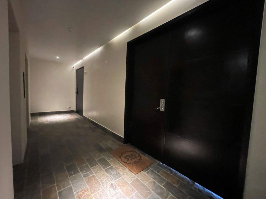 Bedroom with large window, ceiling fan, neutral tones in PH Premier Loft