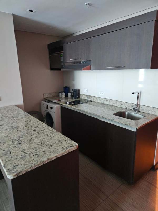 Elegant furnished living room with glass doors to balcony and ocean vistas at PH Megapolis Punta Paitilla