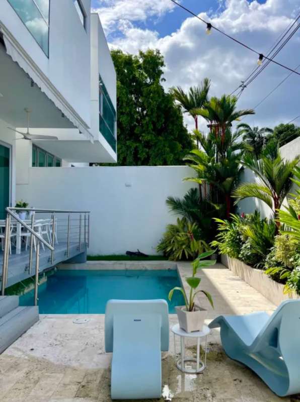 Large master bedroom with high ceilings, wood floors, windows, and contemporary decor in Altos de Golf Panama rental home