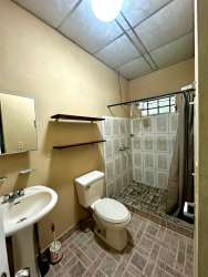 Living area with tiled floors, accent wall and barred windows in Volcán Chiriquí house
