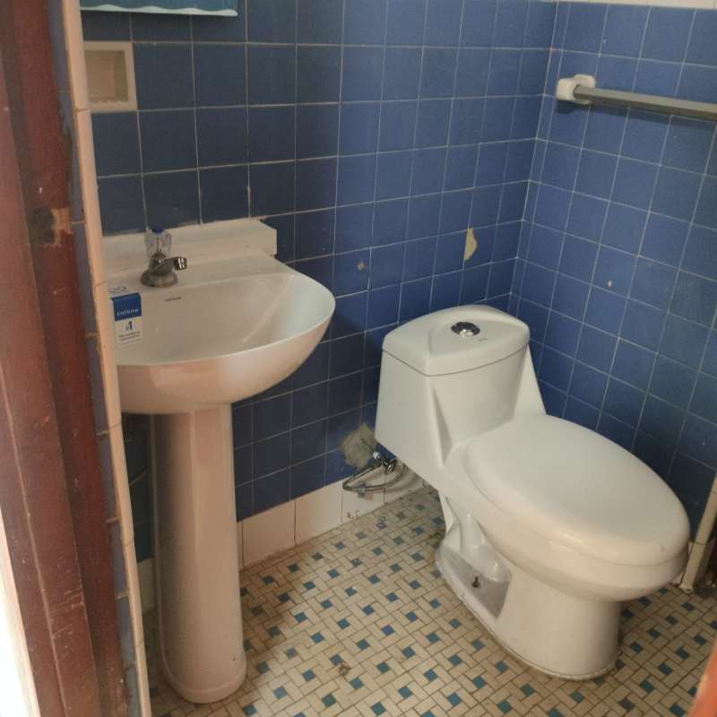 Compact bathroom blue wall tiles pedestal sink toilet PH El Cangrejo Panama