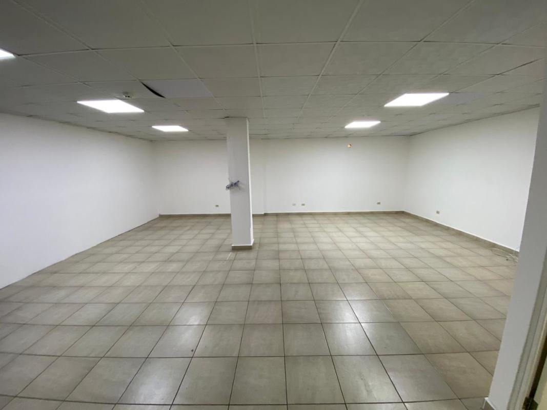 Empty commercial rental space with tile floors, central column and white walls El Ingenio Panama City