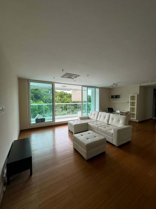 Living room large windows, white sectional sofa, wood floors overlooking nature in Clayton Park II Panama