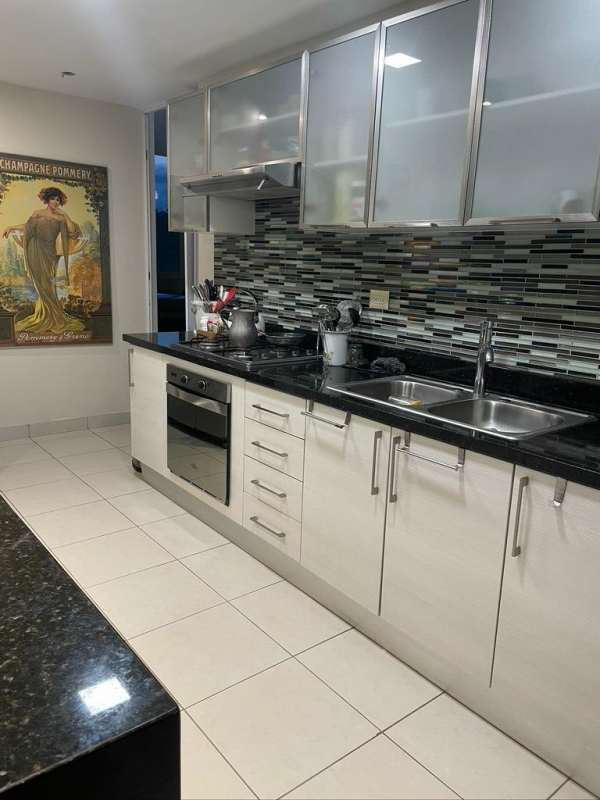 Kitchen with granite counters, double sink, glass cabinets and oven in Clayton Park II Panama apartment