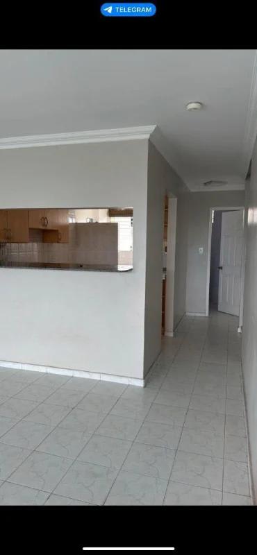 Tiled hallway with partial kitchen view inside apartment PH Miraflores Bethania Panama