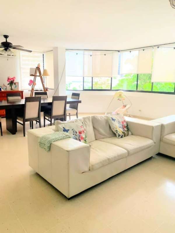 Contemporary living and dining area with large windows, ceiling fan in PH Bay Tower apartment Punta Paitilla Panama