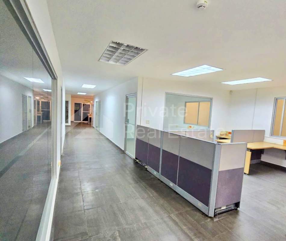 Modern office interior with cubicles, tiled floor and glass window in Centro Logístico Milla 8 Panama City