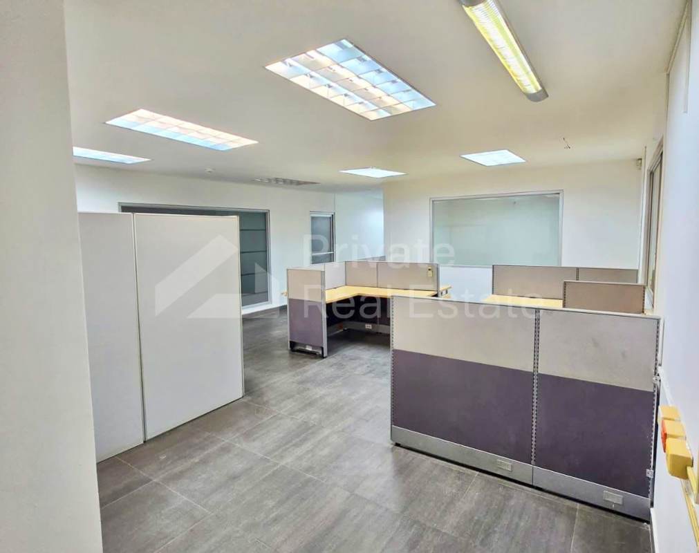 Partitioned office space with cubicles, tile flooring and fluorescent lighting in commercial warehouse Milla 8 Panama