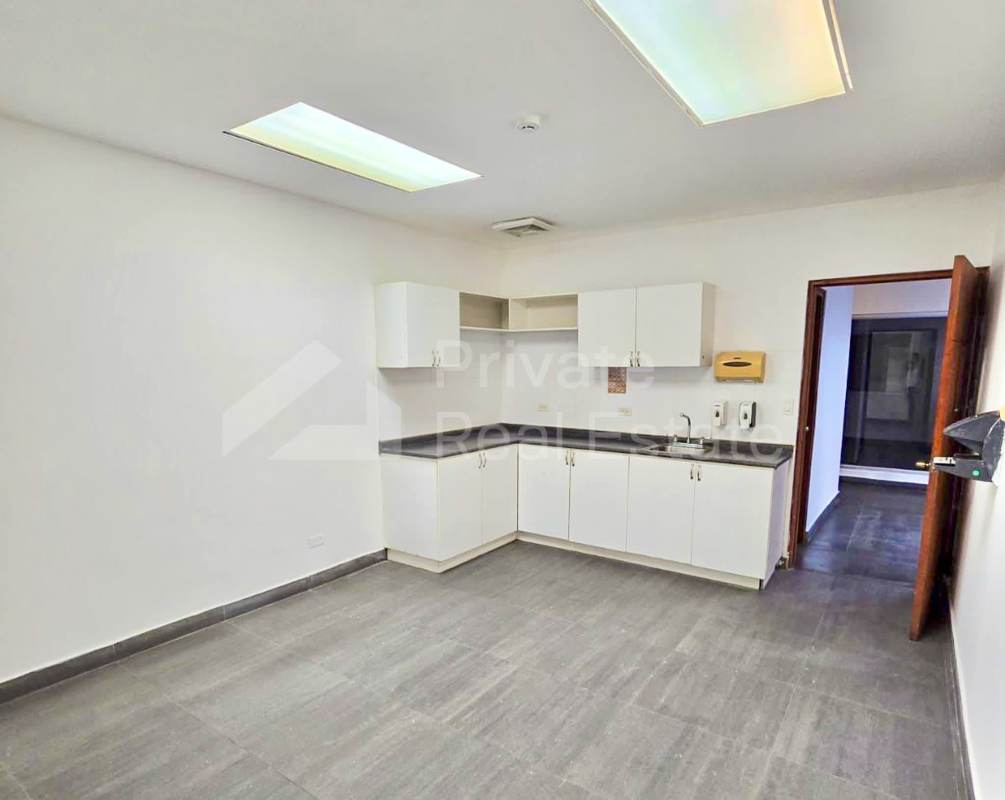 Basic kitchenette with sink, cabinets and tiled floor in office area of Milla 8 warehouse Panama