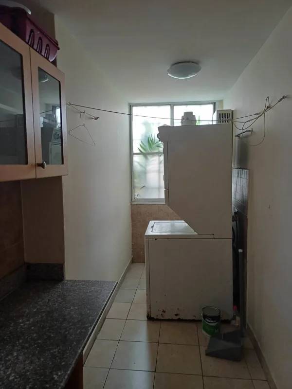 Laundry space with stacked washer dryer, granite counter and window in PH Torre Platinum Via Porras Panama