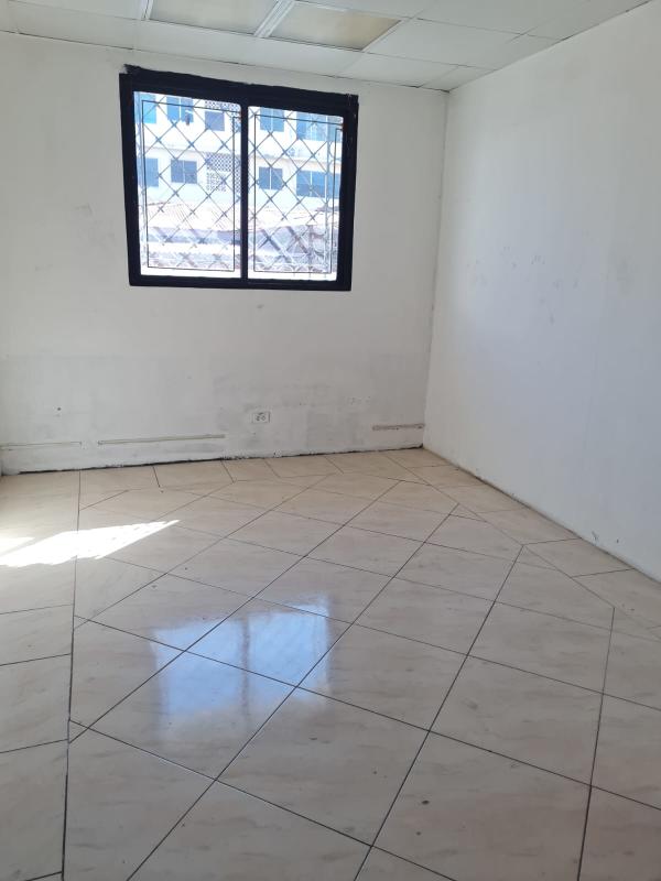 Empty interior room with tiled floor, window with iron bars, minimalist finish for commercial rent Panama