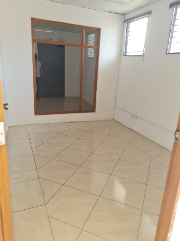 Office with large interior glass window, white walls and tiled floor in Panama commercial space